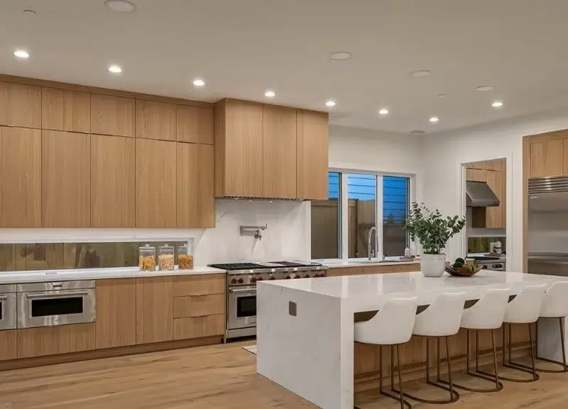 Custom wood kitchen cabinets with a white waterfall island and stainless steel appliances in a remodeled Kirkland kitchen.