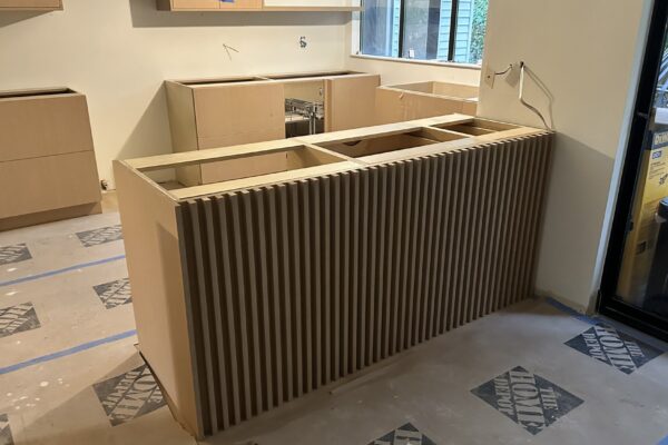 Custom Kitchen Island Construction Custom kitchen island construction with wood-slat paneling