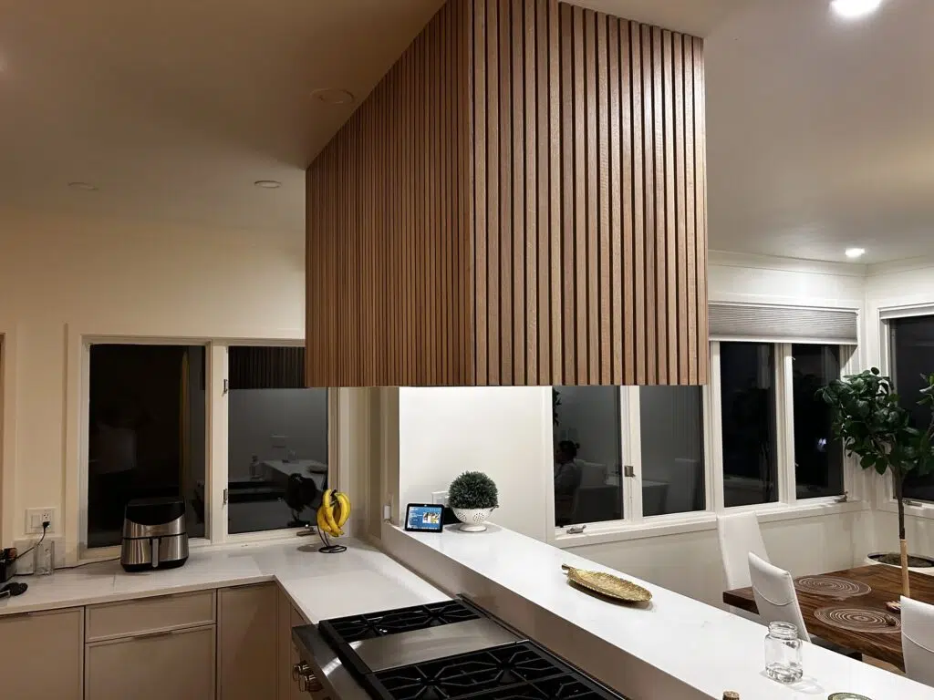 Custom remodeled kitchen with wood-slat cabinetry and quartz countertops