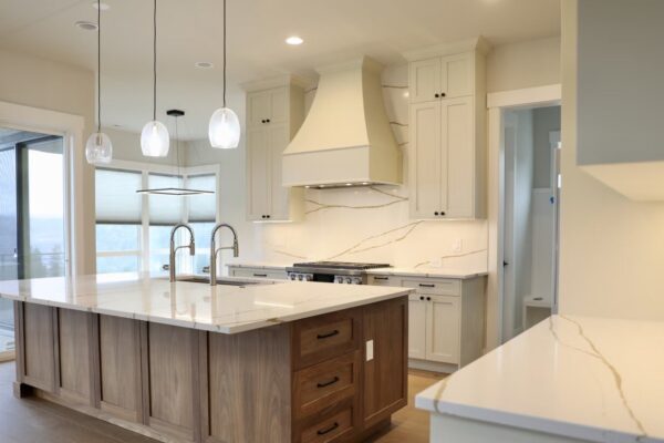 White Kitchen Remodel – Waterfall Island White kitchen remodel with waterfall island and pendant lights